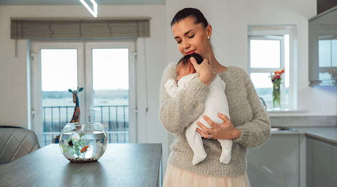 mom holding newborn baby at home