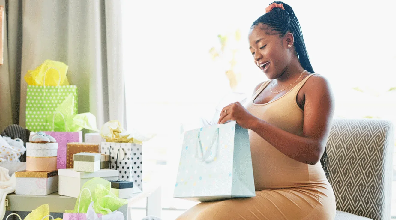pregnant woman opening gifts at baby shower