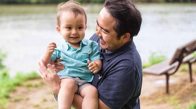 baby being held by his dad outside