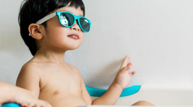 candid photo of toddler wearing blue sunglasses
