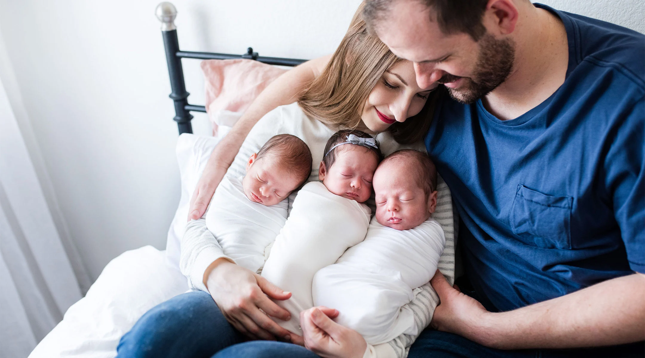 parents holding their newborn triplets