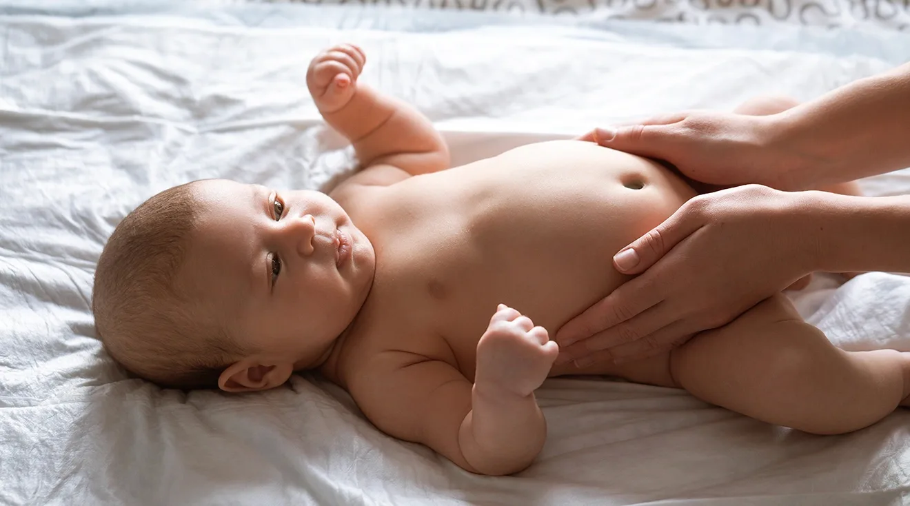 mother giving baby belly massage for constipation relief