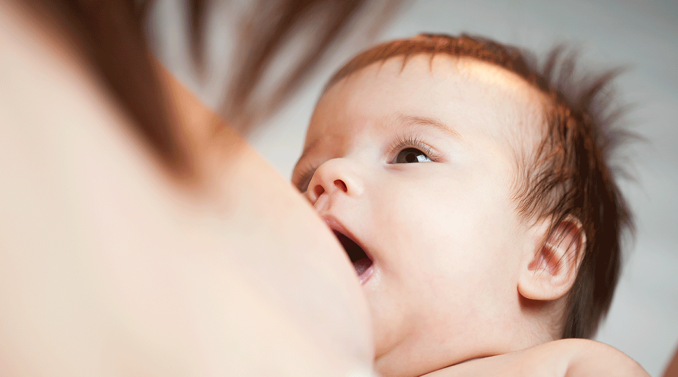 baby with mouth open breastfeeding
