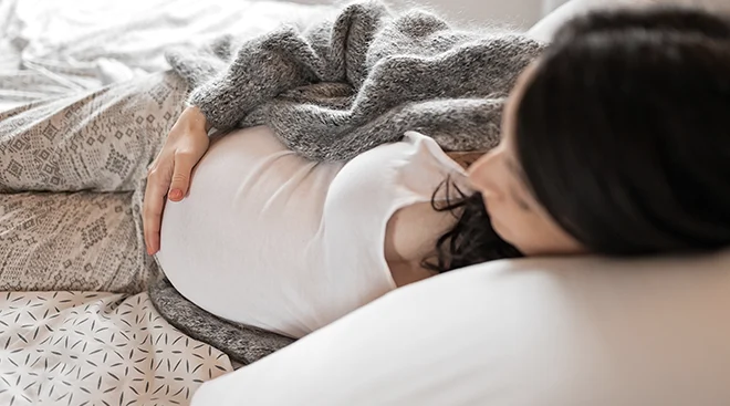 pregnant woman lying down in bed