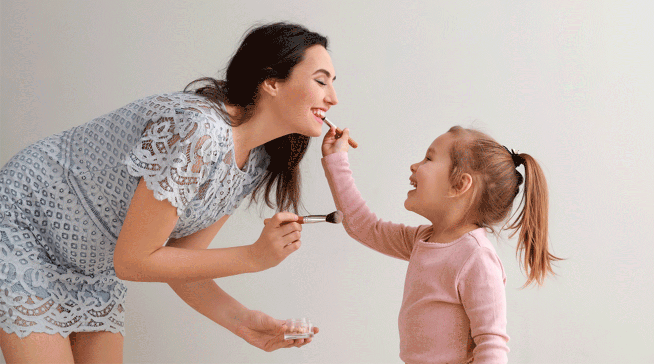 pregnant mom and daughter putting on makeup