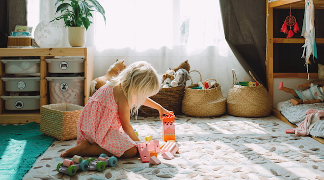 little girl playing with toys in play room