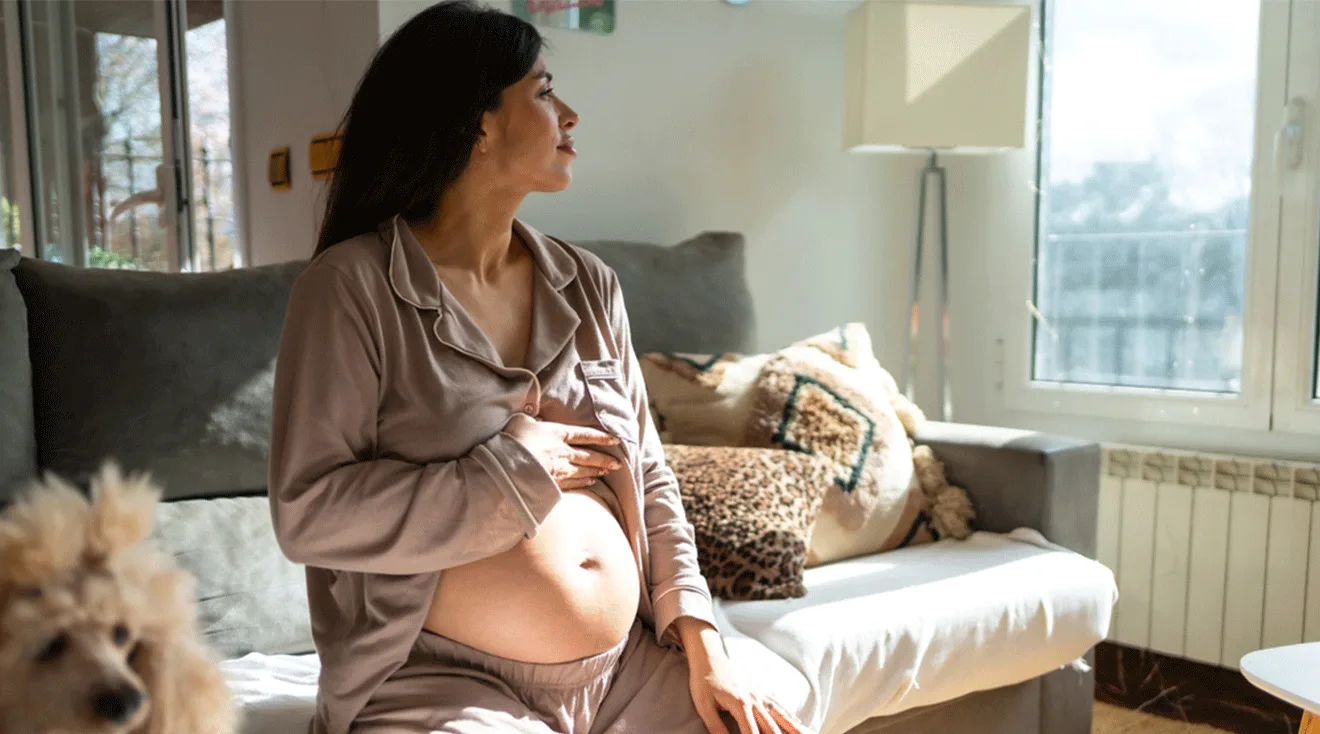 pregnant woman sitting on couch at home