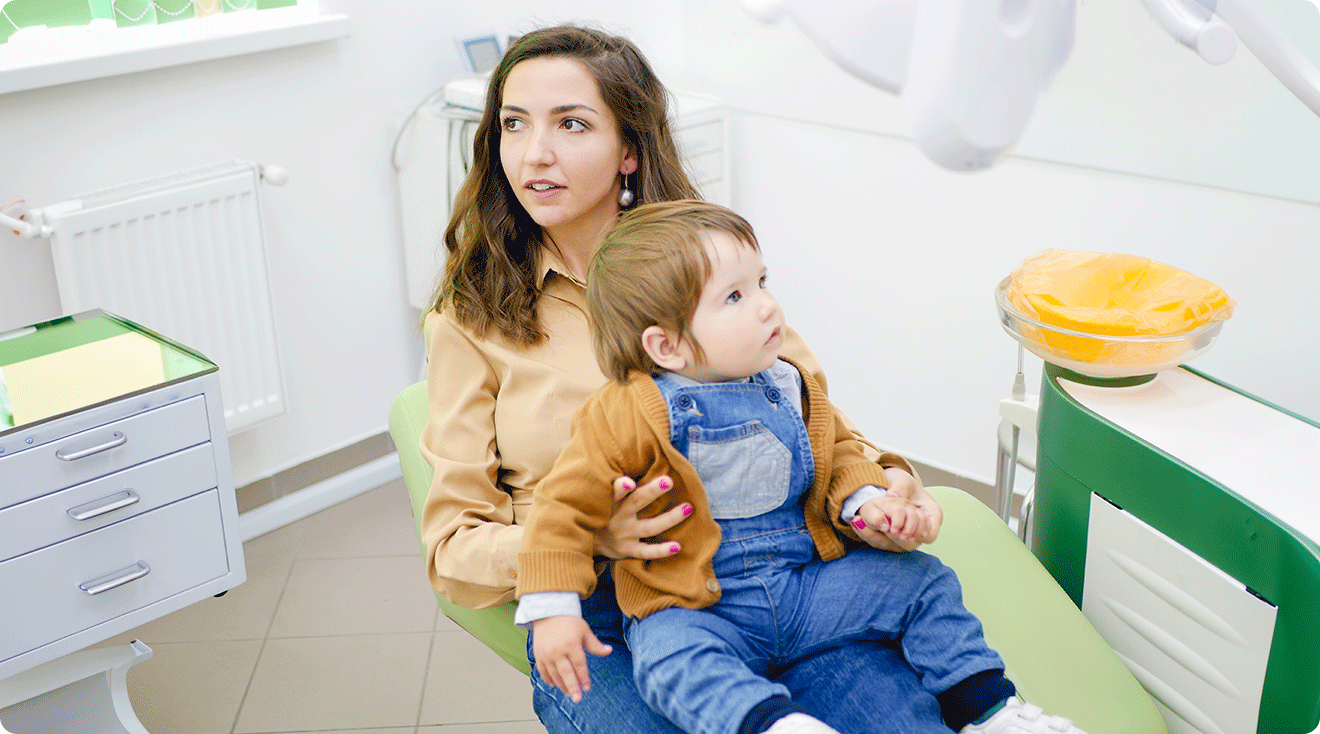mom and baby sitting in dentist chair for baby's first dental check up