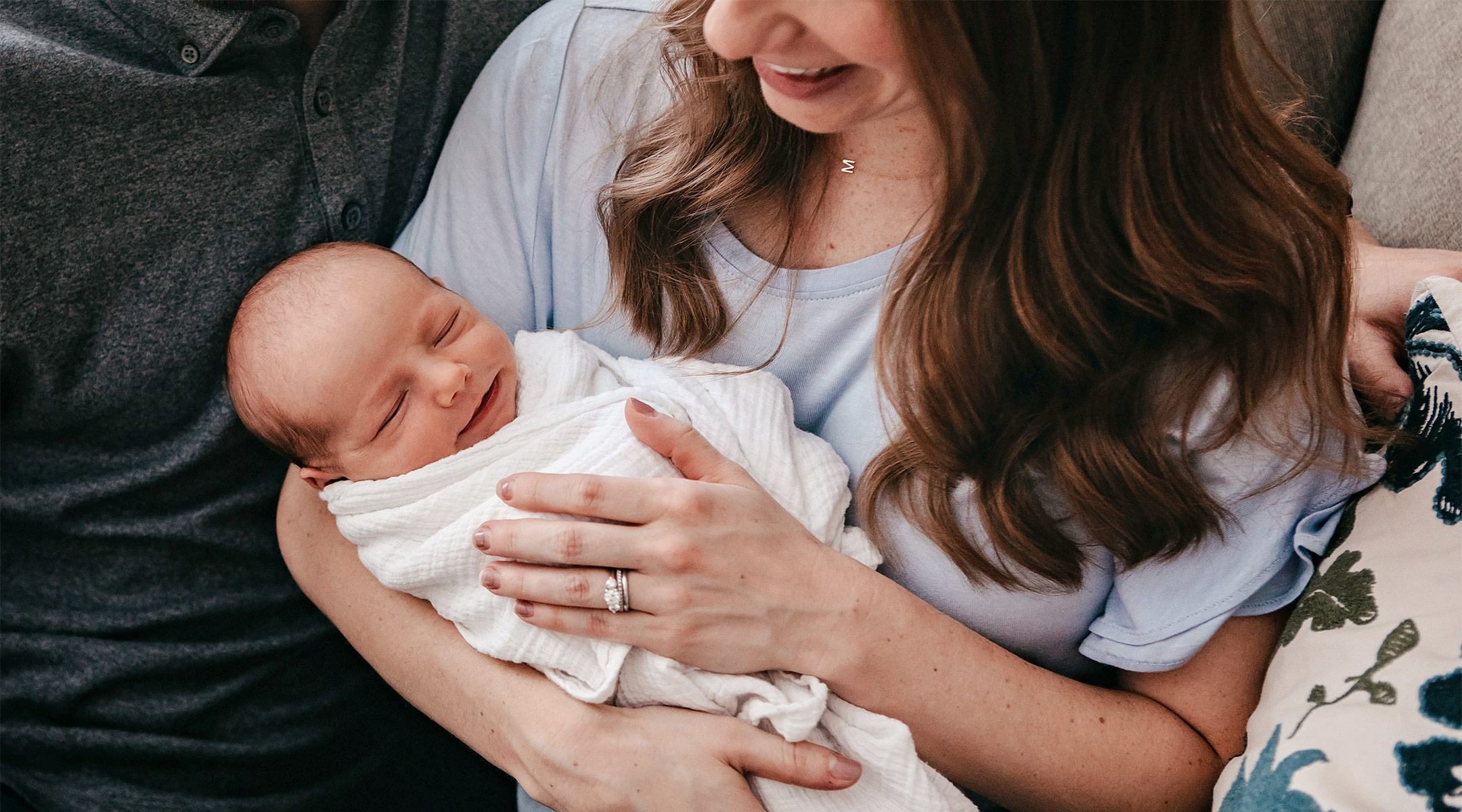 happy newborn baby being held by its parents