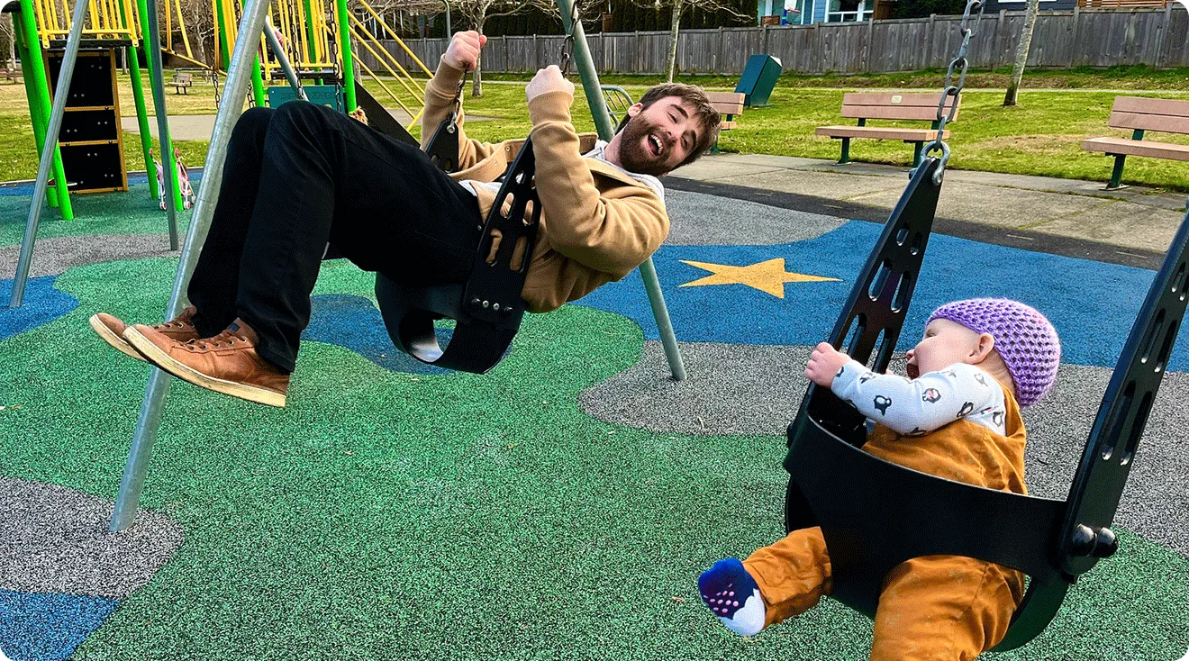 dad and baby having fun on the swings at the playground