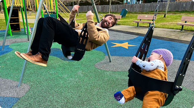 dad and baby having fun on the swings at the playground