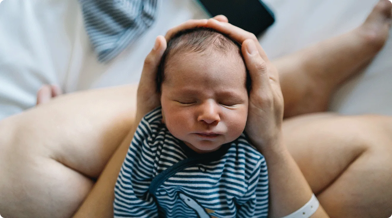 mom holding sleeping newborn baby