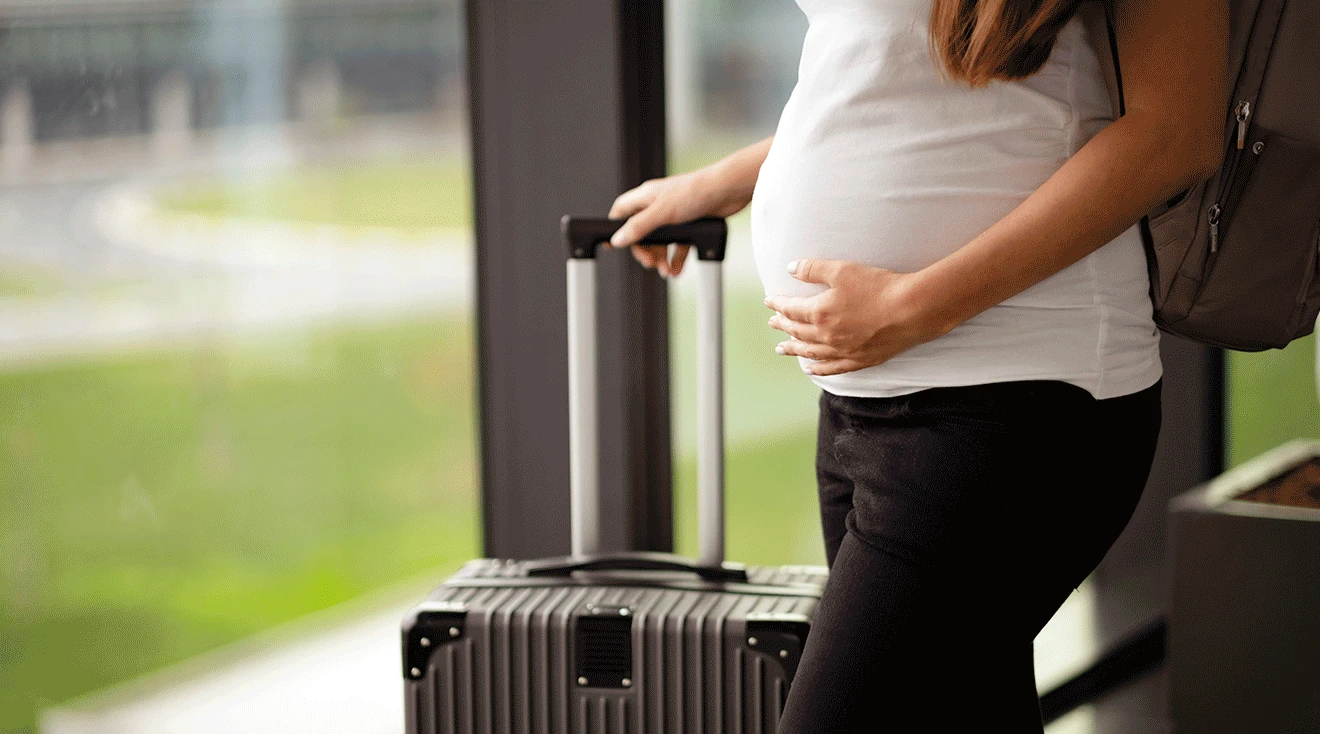 pregnant woman traveling with suitcase