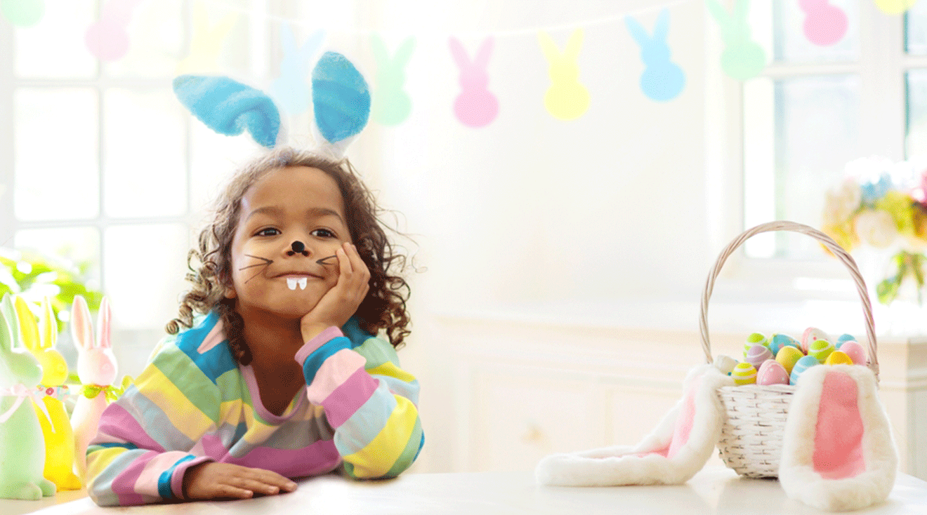 toddler smiling with easter basket and easter decorations