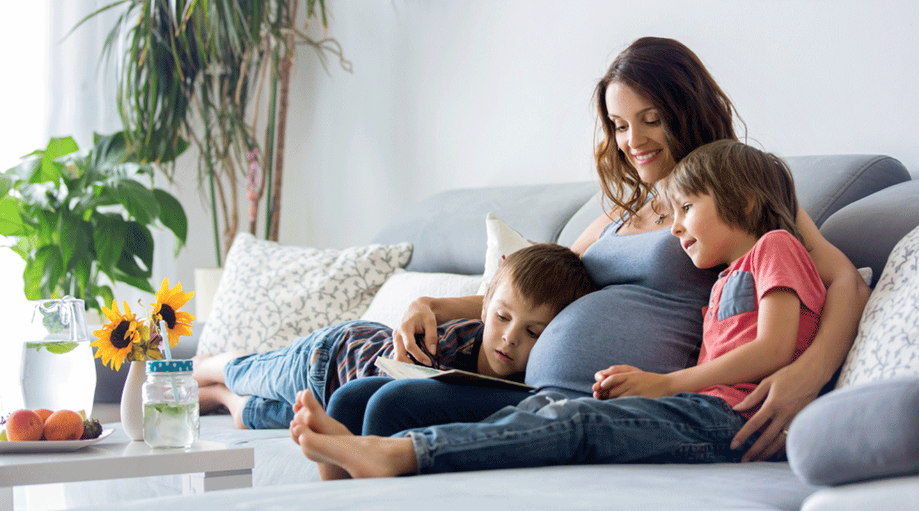 pregnant mom sitting on couch with 2 children