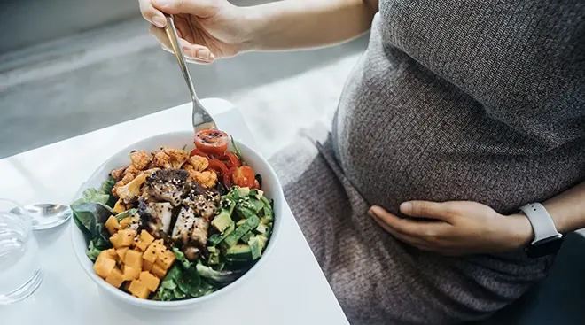 close up of pregnant woman eating a salad