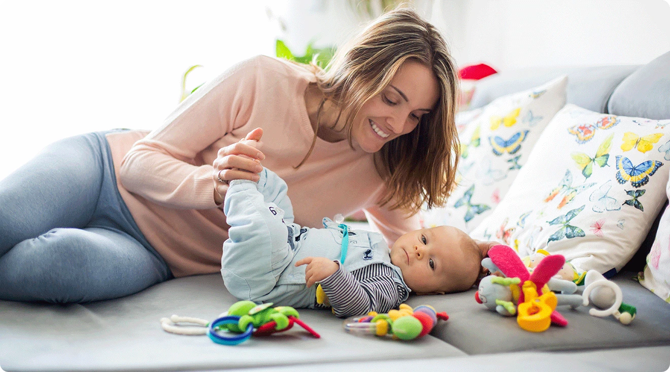 mom playing with newborn baby toys