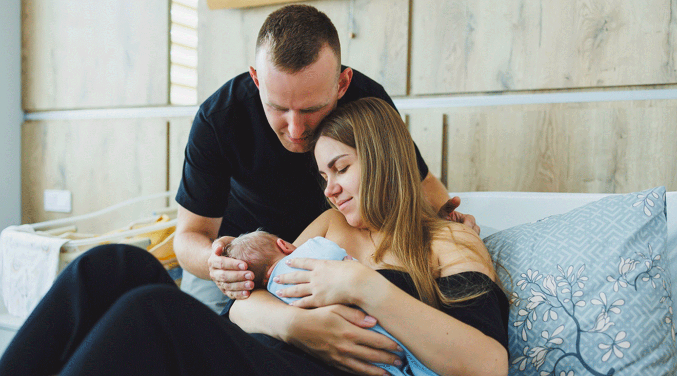 father supporting postpartum mother with newborn baby