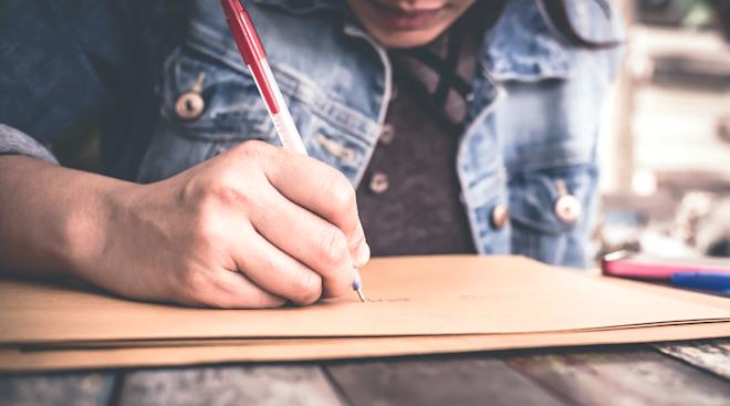 close-up of woman writing a note