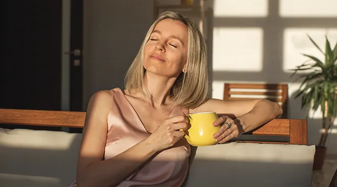 woman holding a cup of coffee and relaxing in the morning at home