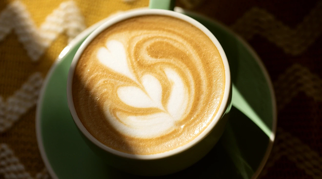 close up of a cappuccino in a green mug