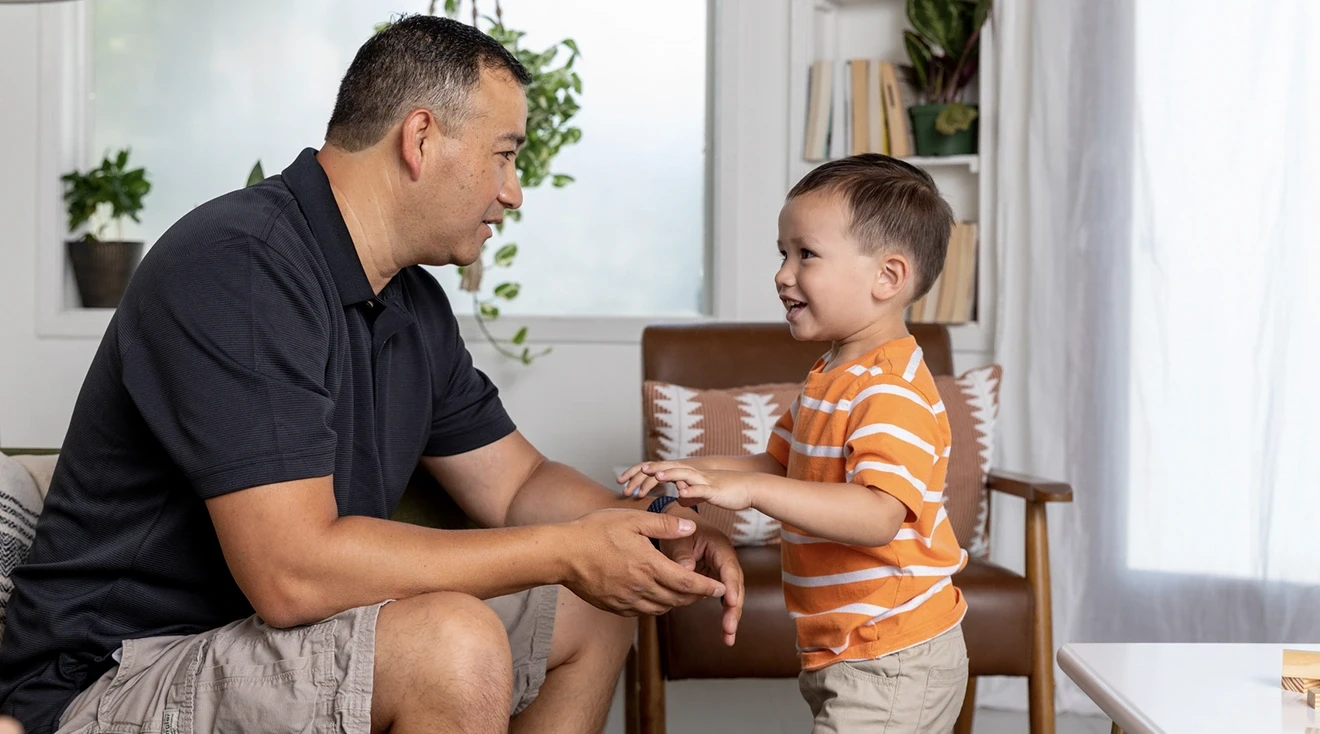 father and toddler son talking at home