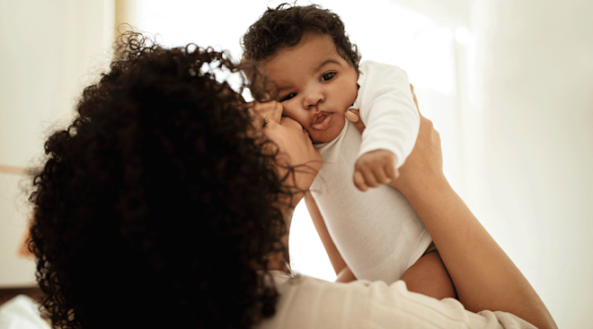 mom kissing baby at home