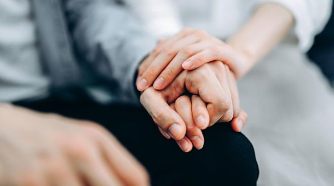 partners holding hands after suffering pregnancy loss