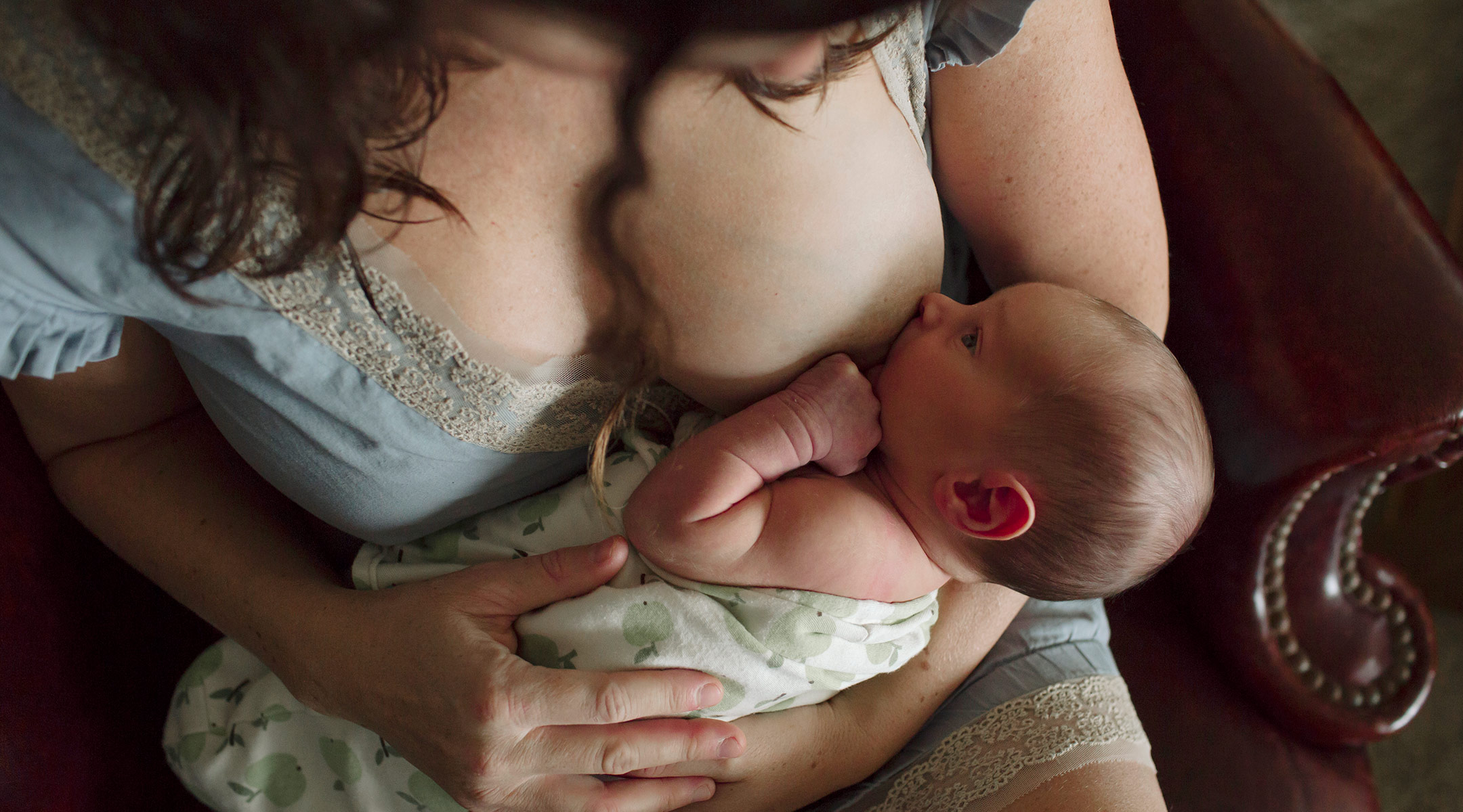 mom breastfeeding in a dark serious setting