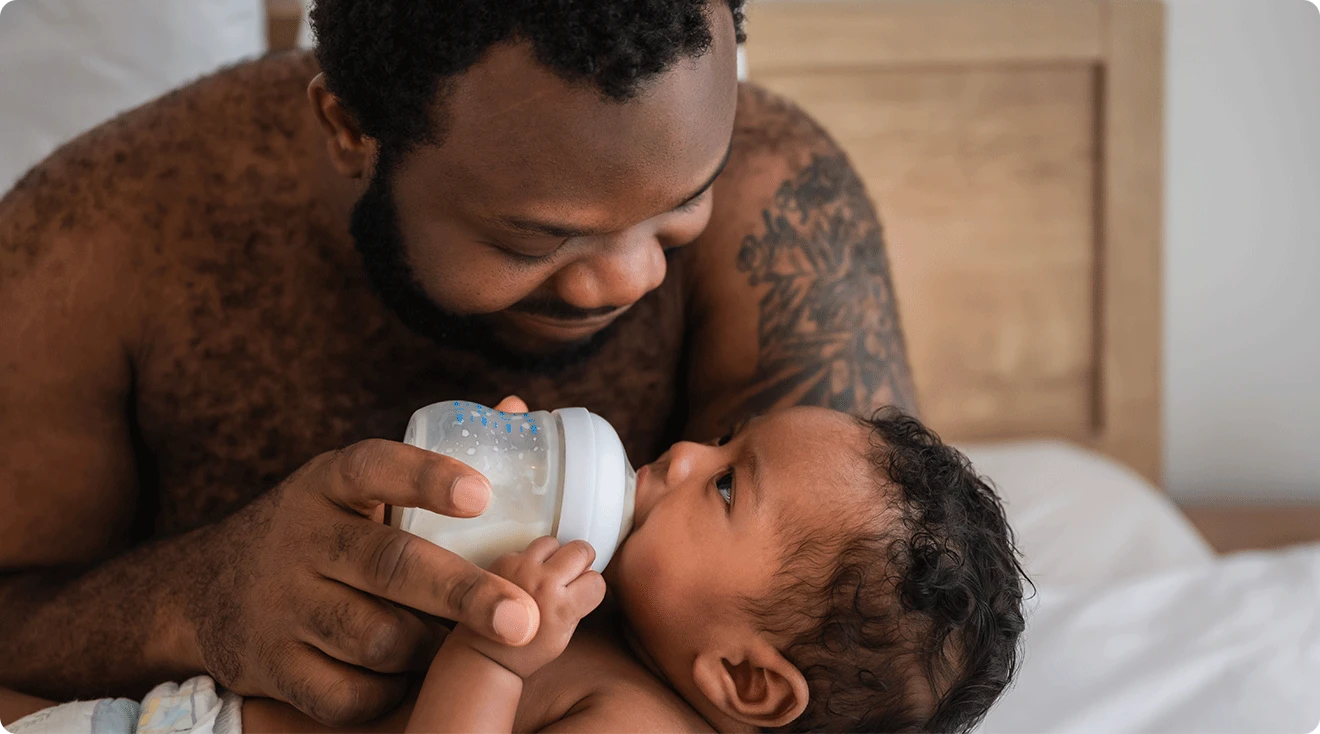 father giving a bottle to baby