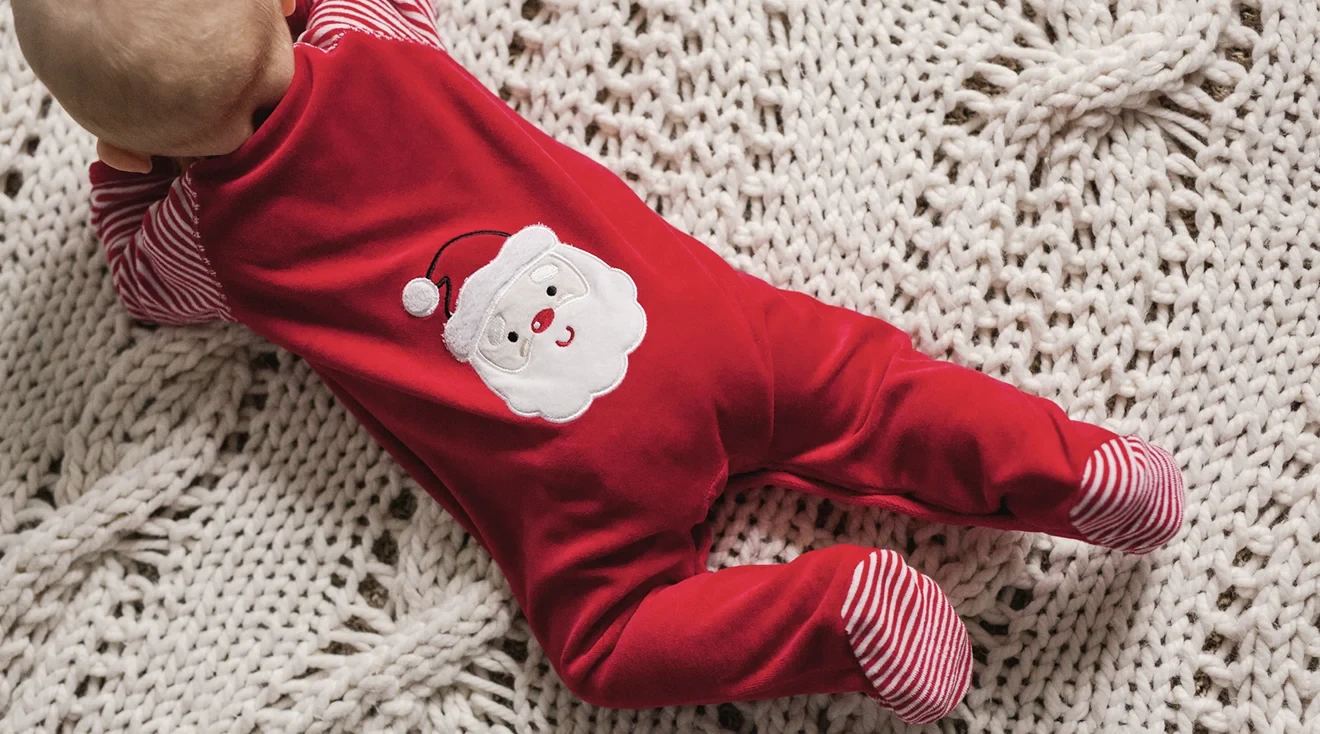 top view of baby wearing a christmas santa onesie