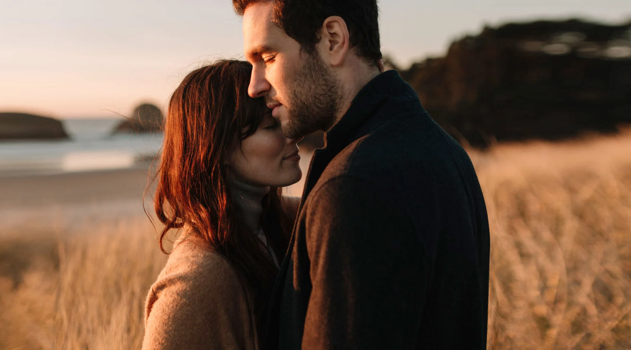 contemplative couple embraces in beautiful outdoor scenery
