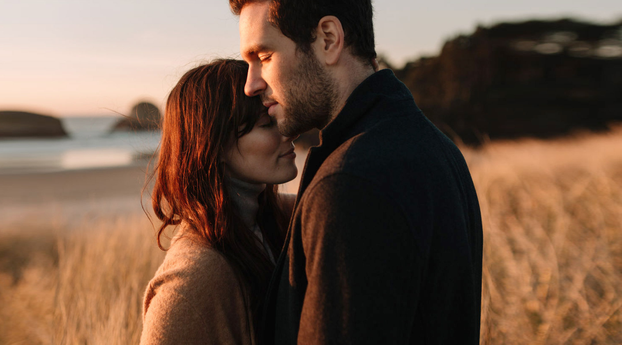 contemplative couple embraces in beautiful outdoor scenery 