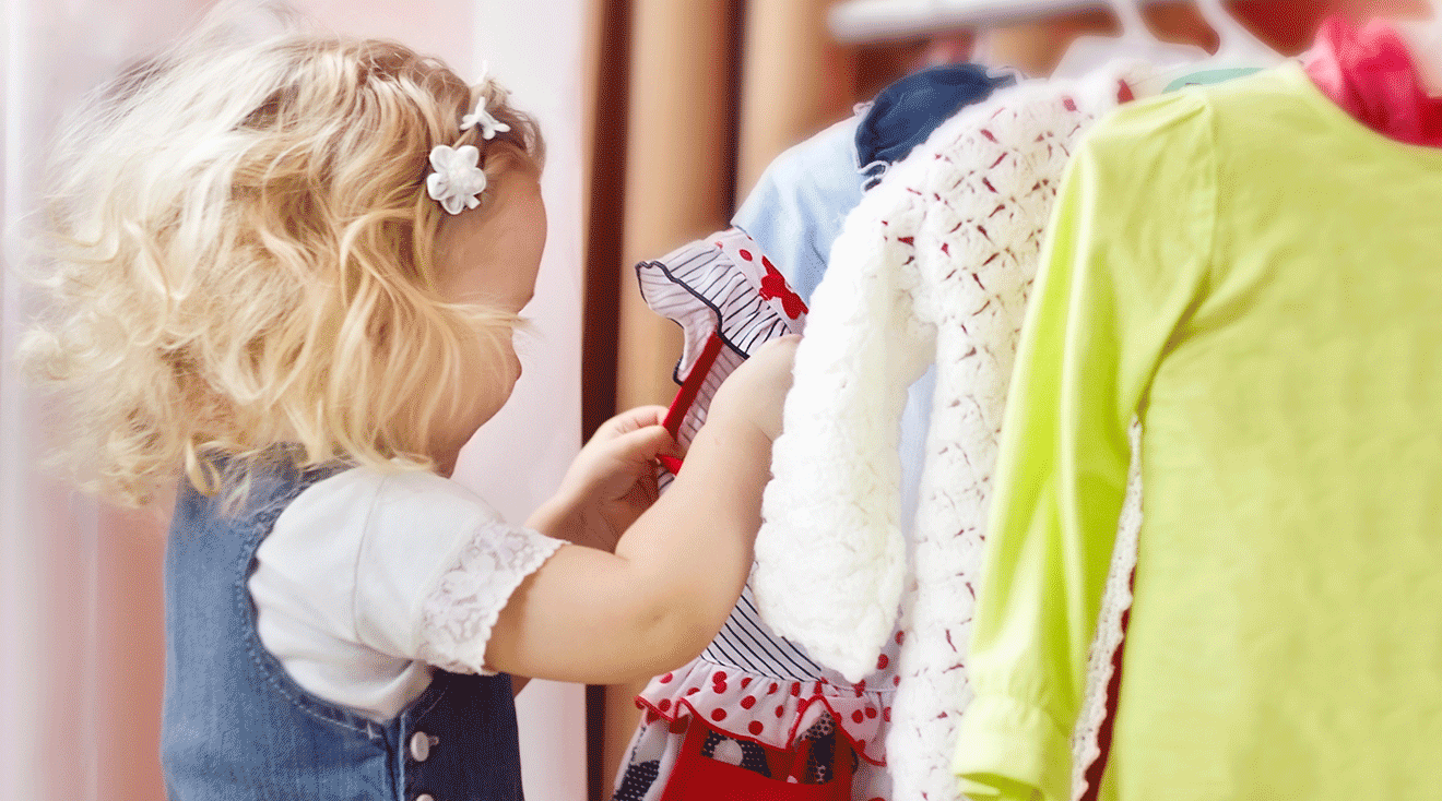 toddler girl choosing clothes from closet