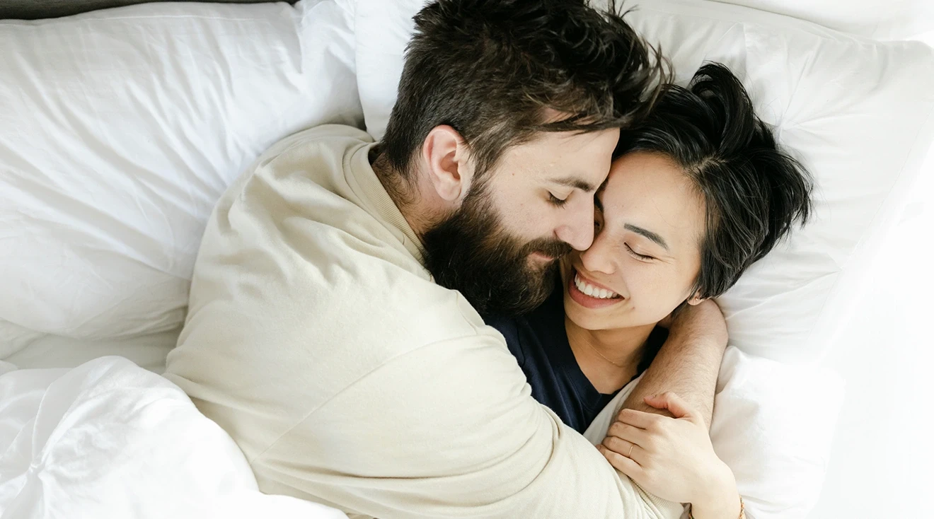 couple hugging and smiling in bed