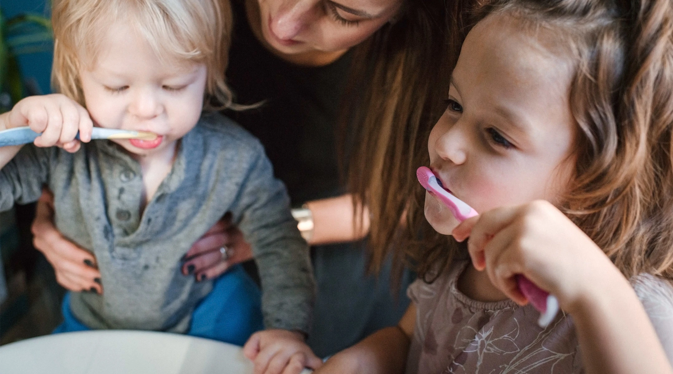 toddler siblings brushing teeth together