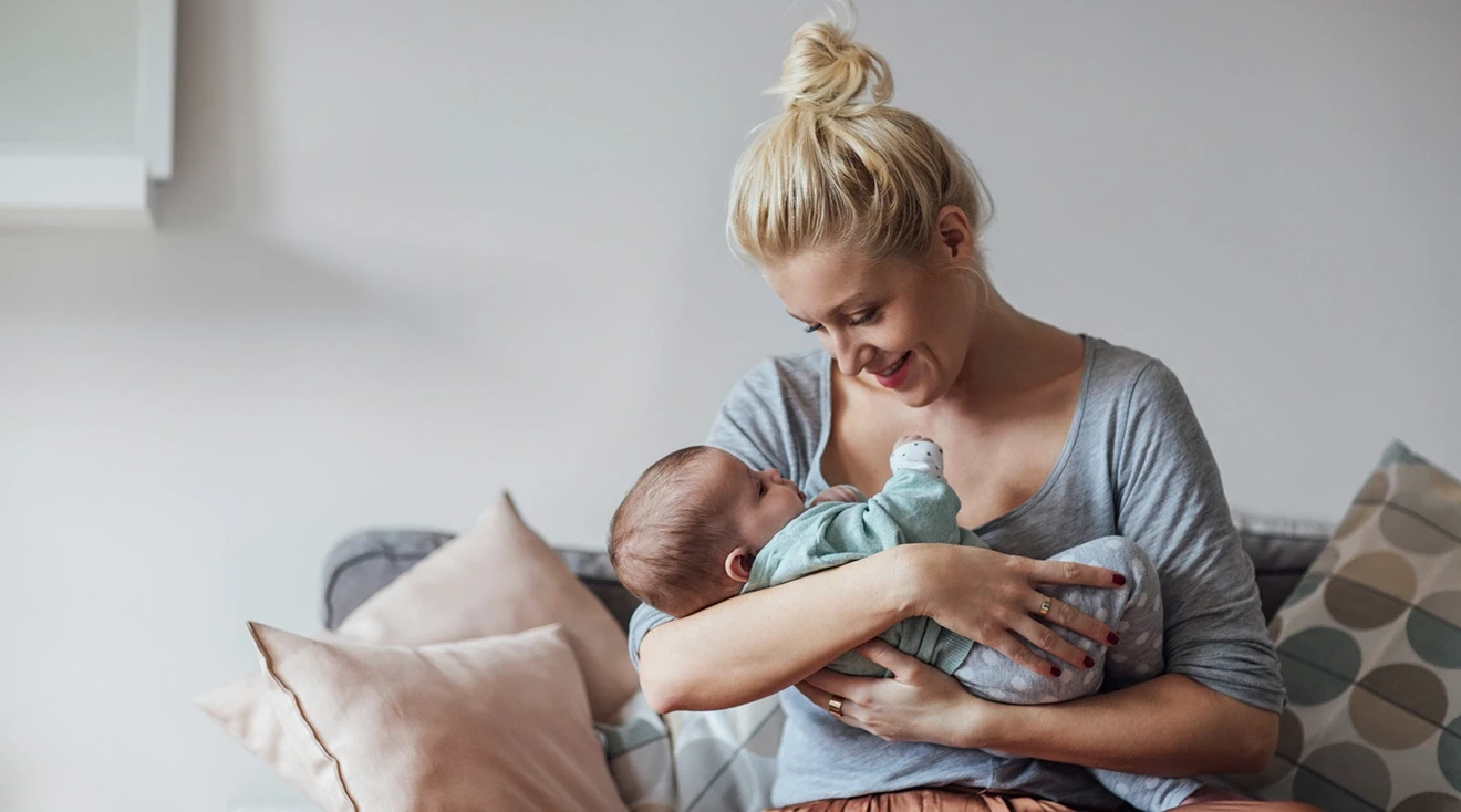 mom holding baby and smiling