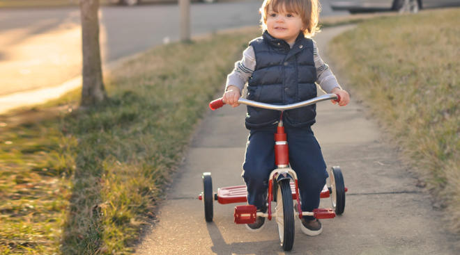 toddler riding his tricycle through neighborhood