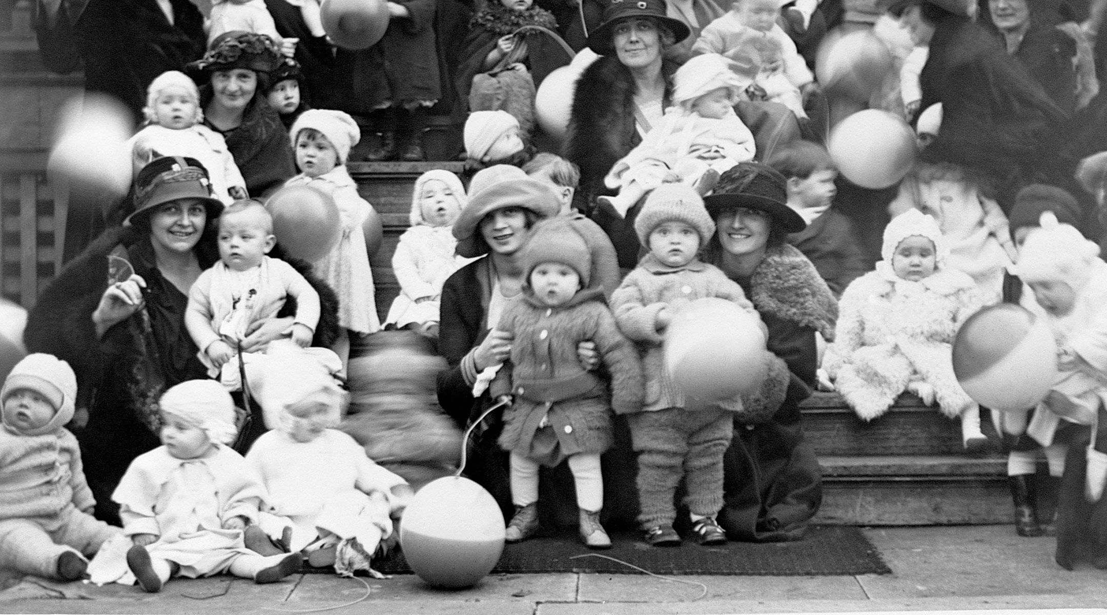 babies and moms posing on stoop for better baby contest in 1920s