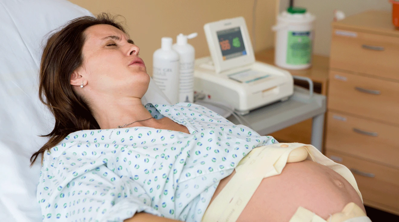 pregnant woman in labor having contractions in hospital bed