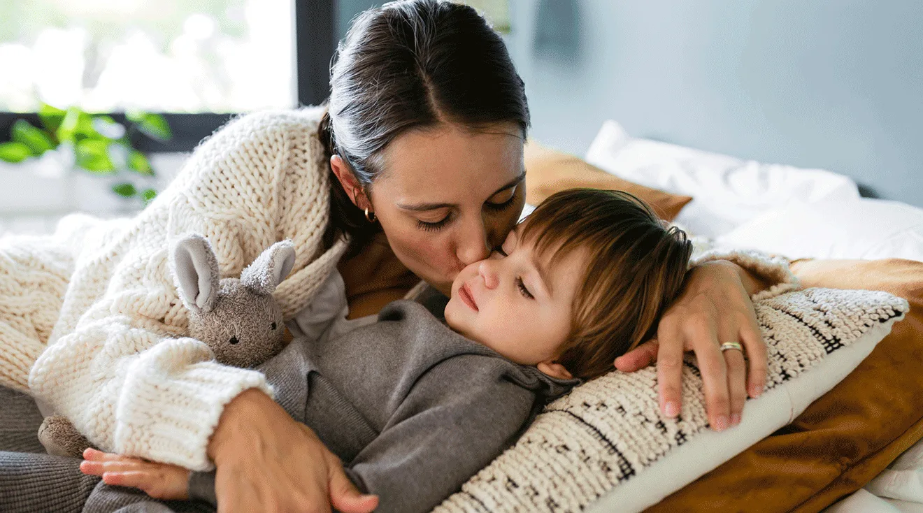 mother kissing her toddler son at home