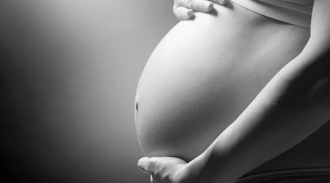 black and white image of pregnant belly, maternal deaths increase in 2021