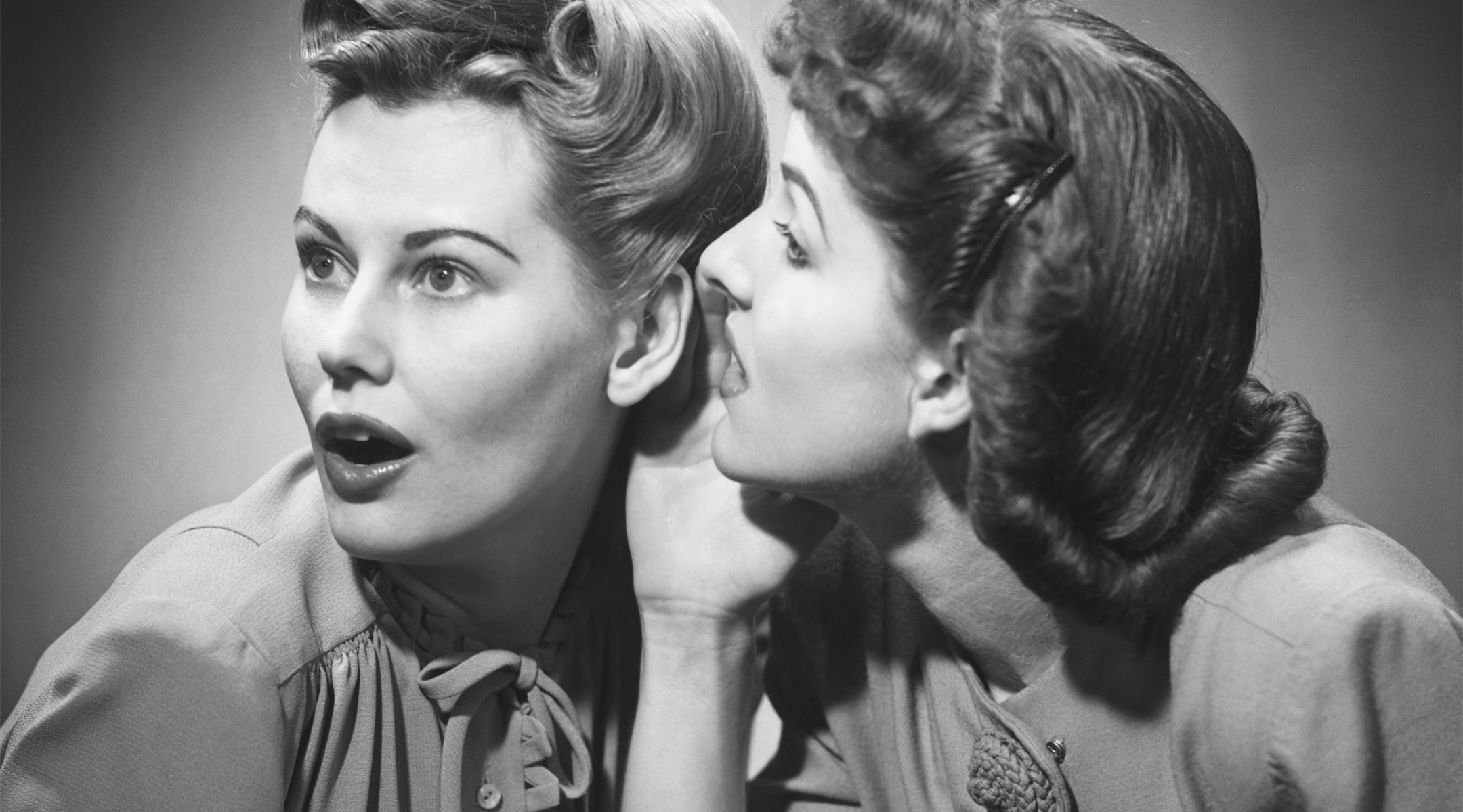 retro black and white image of two women whispering