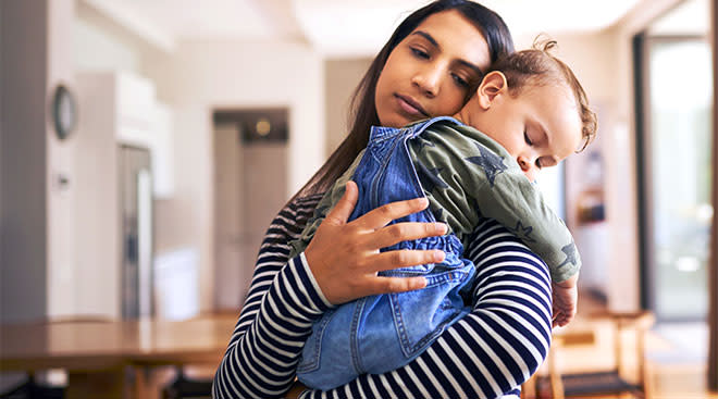 tired mom holds her toddler