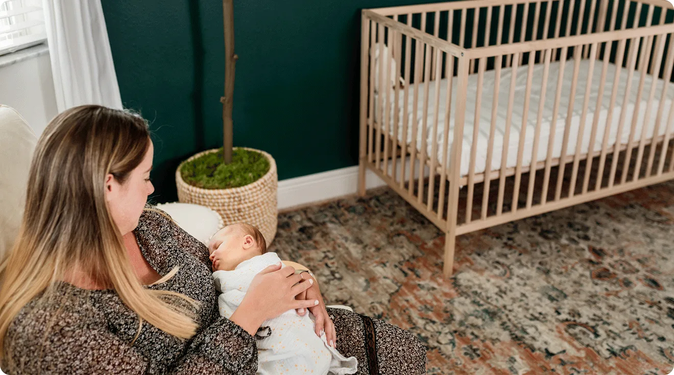 mom holding baby in baby nursery