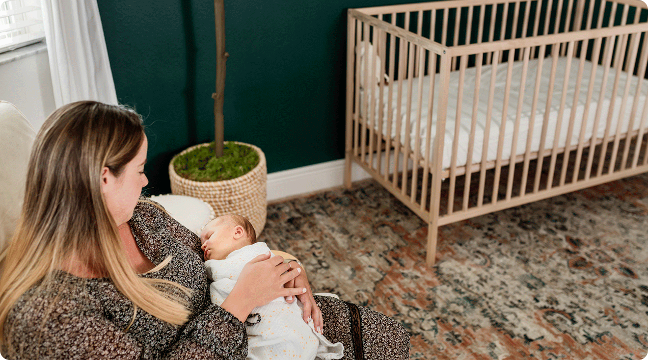 mom holding baby in baby nursery