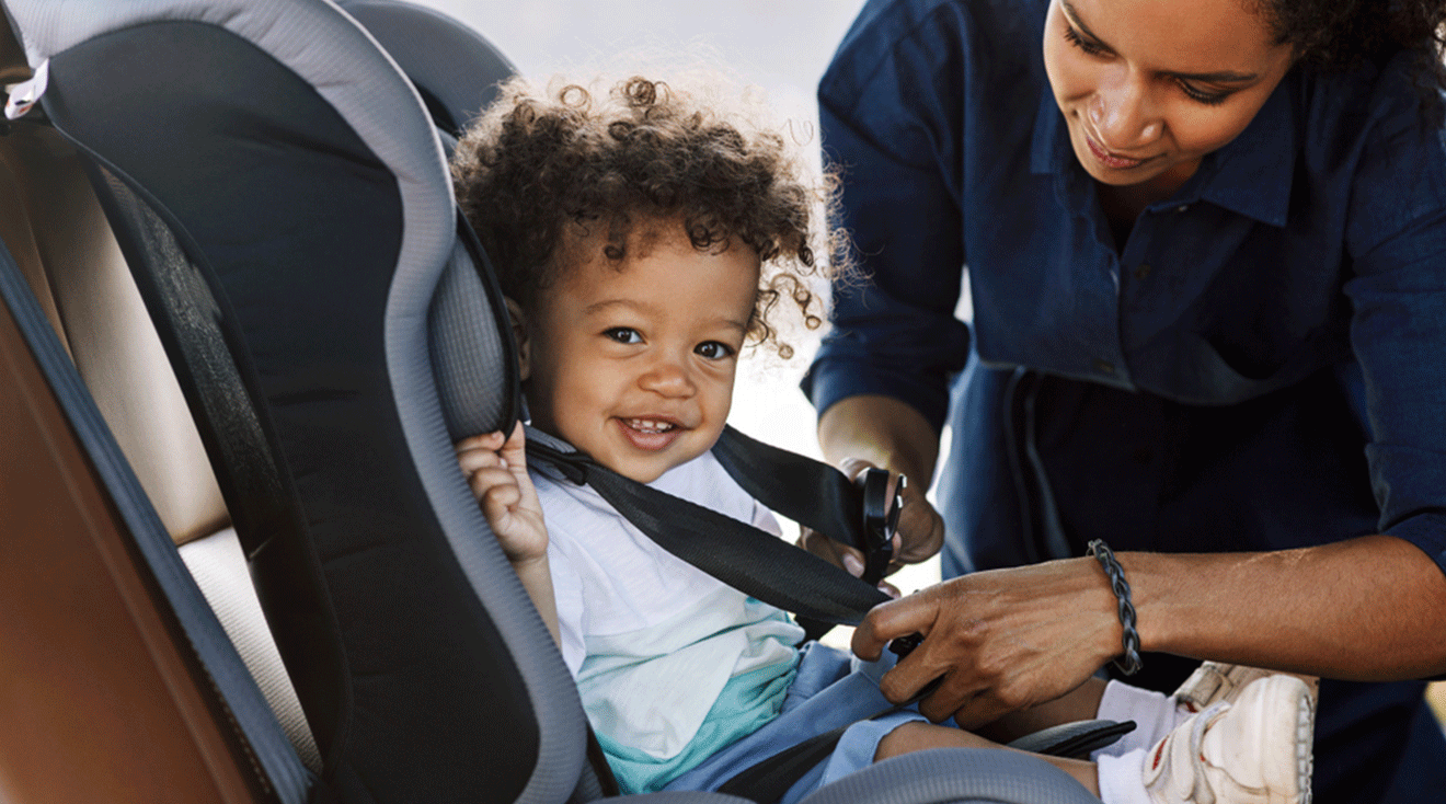 mom buckling baby into car seat