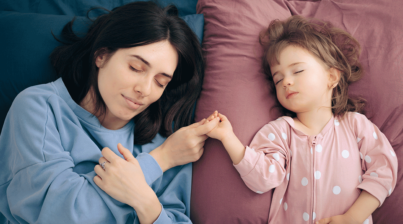 mom and toddler sleeping next to each other while holding hands