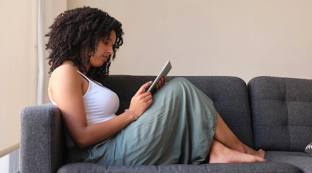 woman reading tablet on the couch at home