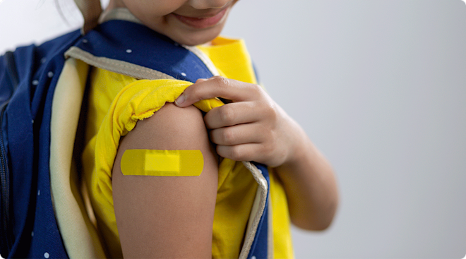 child wearing band aid after vaccine for school